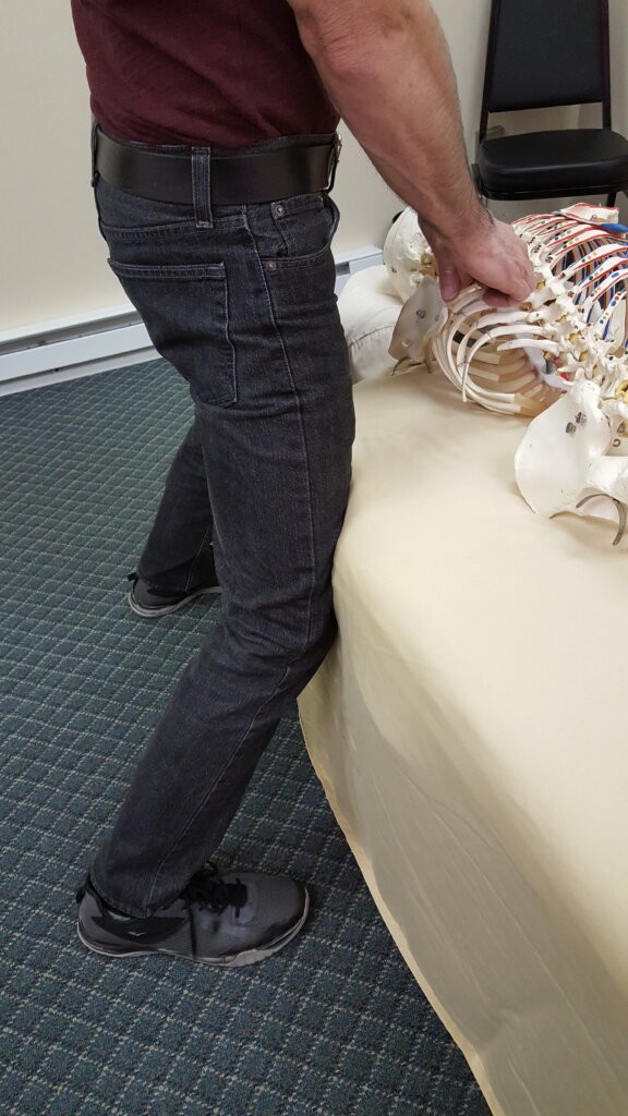 Massage therapist leaning into the massage table for footwork