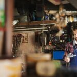 Professional mechanic thoughtfully selecting a tool from a well-organized tool chest