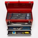 Extensive toolbox illustrates that changing a car battery requires only a select few tools, not an entire mechanic's set.